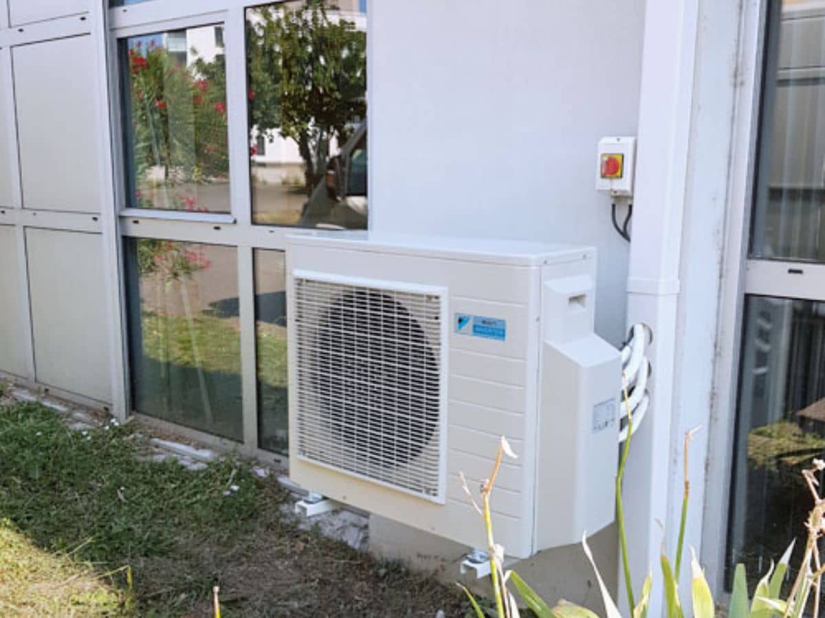 Groupe extérieur Daikin installé au sol devant un bâtiment d’établissement scolaire