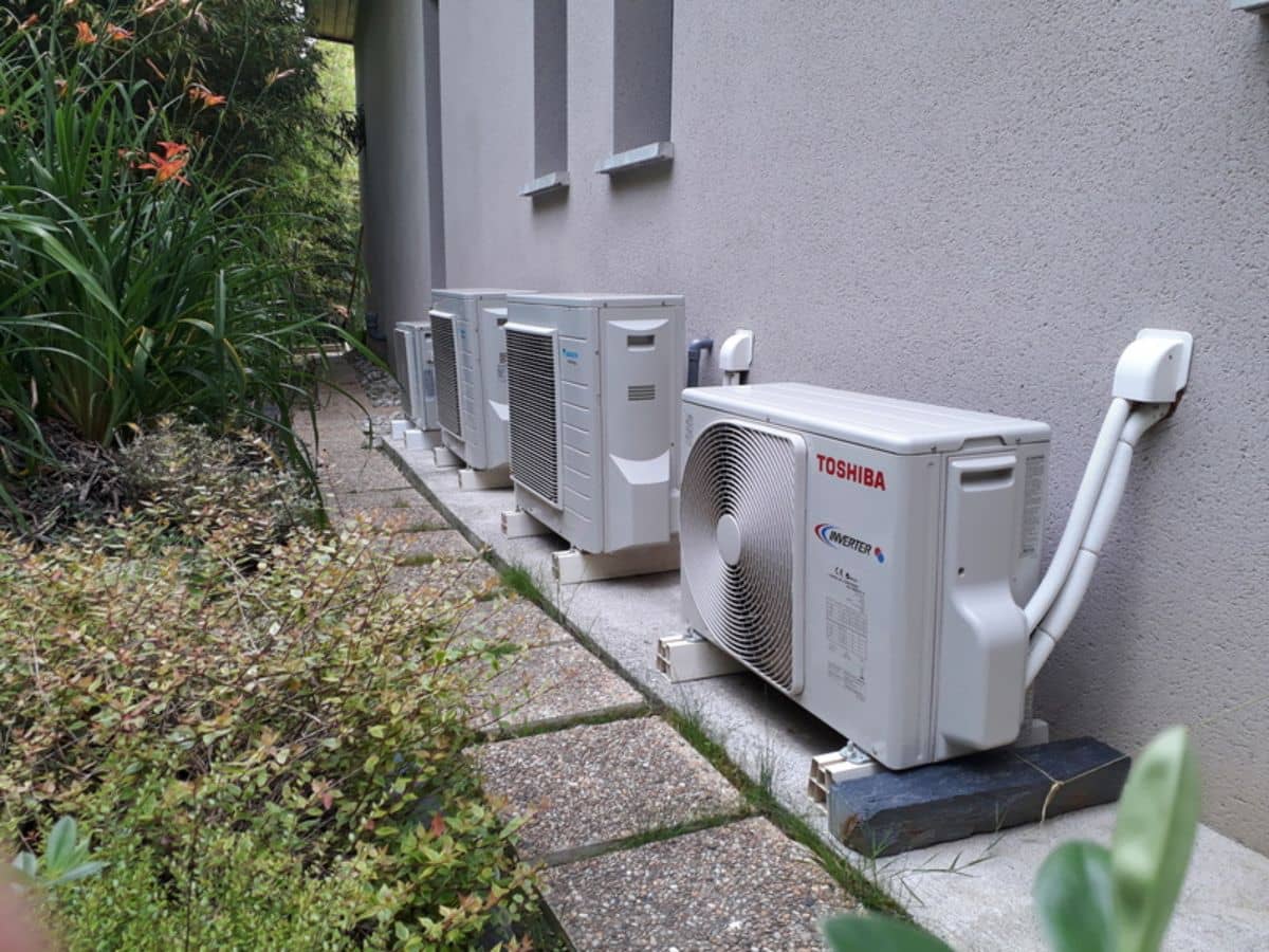 Groupes extérieurs posés au sol sur supports le long d’une maison, par Qualiclim