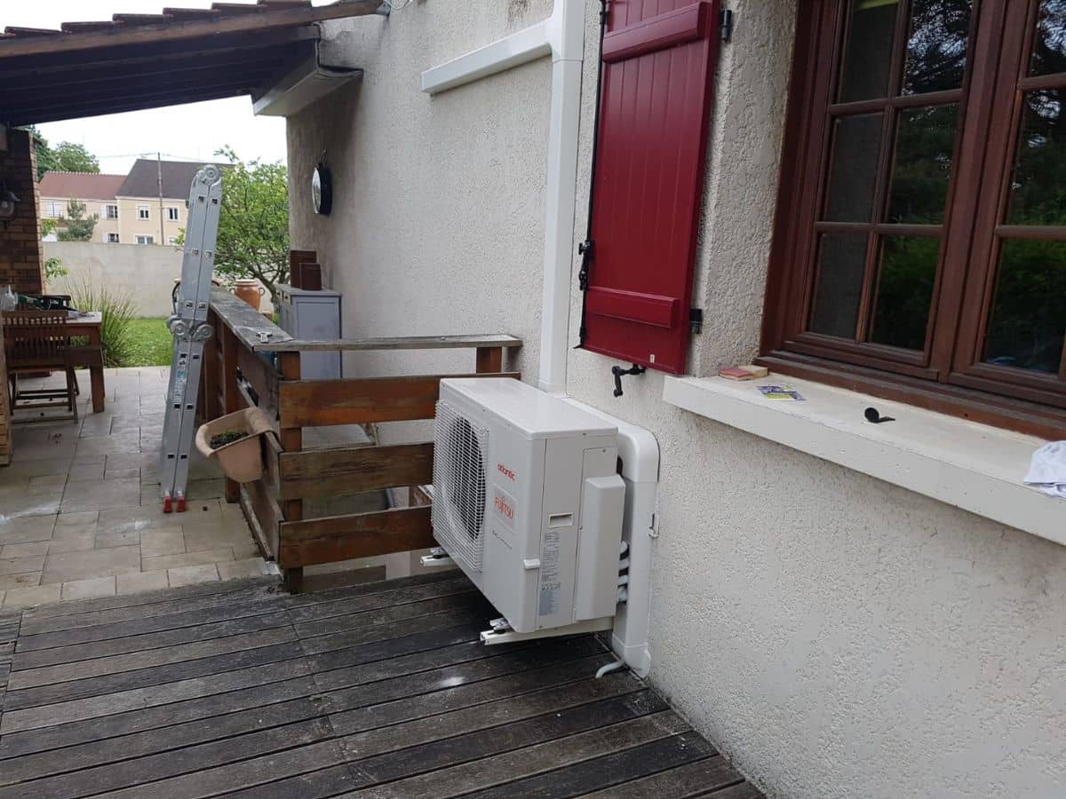 Groupe extérieur de climatisation réversible posé sur une terrasse en bois