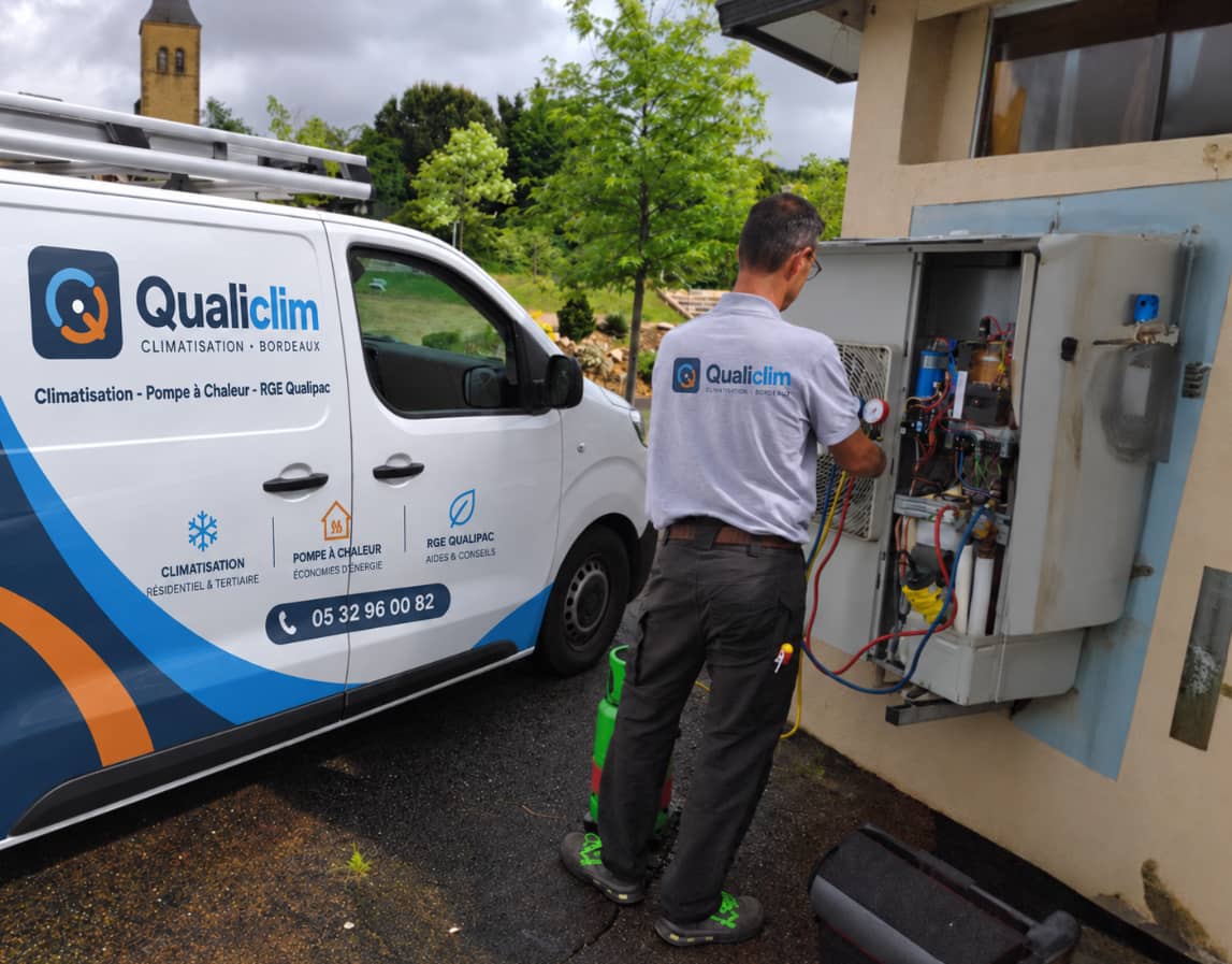 Technicien Qualiclim intervenant sur une armoire technique d’un local professionnel